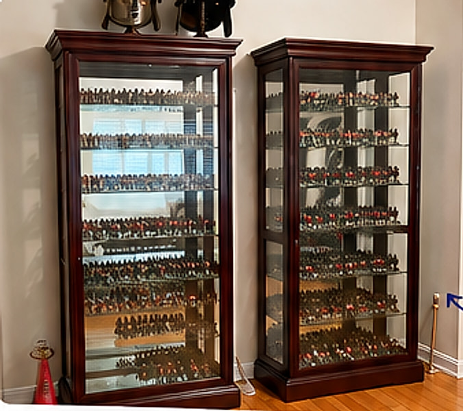 Two tall glass display cabinets filled with rows of painted toy soldiers